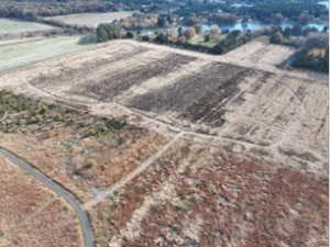 aerial view of a grassy field with a loop of trail freshly moxed through it